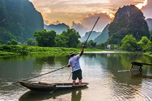 Pole: Fisherman on boat in Trang An, a scenic area near