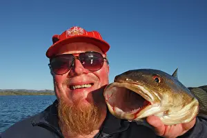 Anglers: Fisherman - holding up catch of a cod