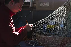 Cabo: Fisherman repairs a net in his fisherman's cottage