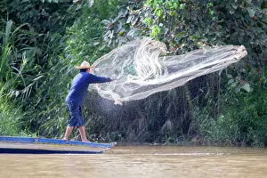 Throwing: Fisherman throwing net from boat