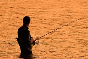 Bodies: Fisherman wearing a chest wader standing in the