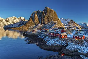 Norwegian: Fishermen's Village in front of snowy mountain range at the coastline in winter