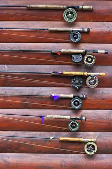 Cabin: Several fishing rods hanging on cabin wall outside, Lake