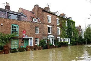 Opposite: Flooded road and houses opposite Tewkesbury Abbey