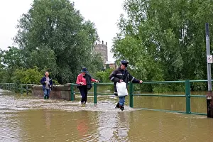 Opposite: Flooding - People walking along flooded road opposite