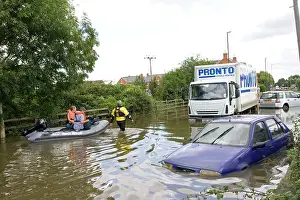 Lorry: Flooding - rescue workers taking people in inflatable