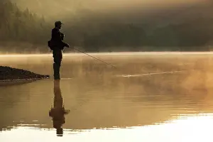 Fisherman: A fly fisherman standing on the shore of the Obernau