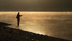 Fisherman: A fly fisherman standing on the shore of the Obernau