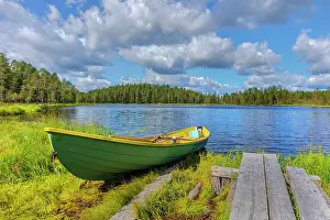 Rowing: Forest lake - colourful rowing boat sitting on the shore of
