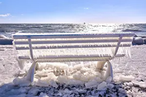 Heavy: Frozen lighthouse and pier on stormy winter day