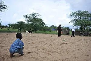 Daily: Fulani child crouched in the sand Senegal