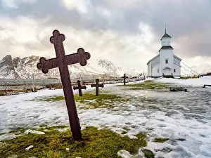 Lofoten: Gimscy church with cemetery, snow-covered mountains