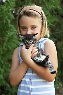 Cuddle: Girl cuddling a kitten - France
