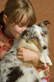 Holdiing: Girl - cuddling puppy