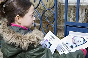 Railing: Girl distributing posters to find his lost dog