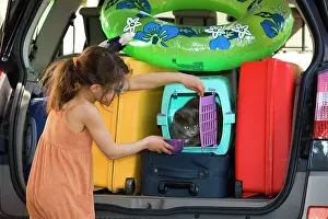 Packed: Girl - giving cat a drink - in rear of packed car