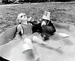 Sunglasses: Girl with monkey sitting relaxed in the swimming p