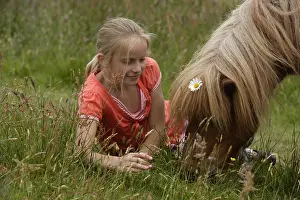 Tendernesses: Girl with her Pony in a meadow Netherlands