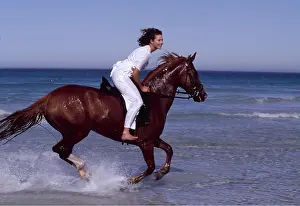 Exercising: Girl rides HORSE - galloping along sea edge