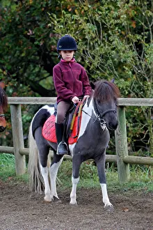 Exercising: Girl - riding pony in paddock