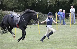 Jumped: Girl running race black pony mid air Gymkhana UK