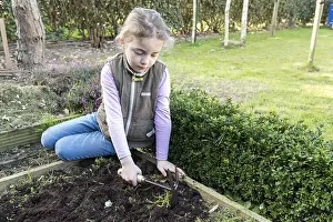 Lifting: Girl weeding a vegetable patch with a hoe, Pas de