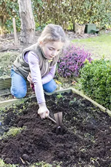 Lifting: Girl weeding a vegetable patch with a hoe, Pas de