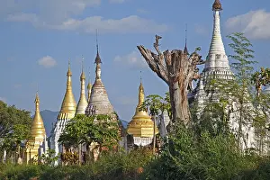 Burmese: Golden and white Buddhist Stupas on the shore along I