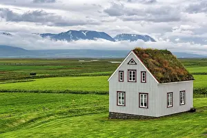 Northeastern: Grass sod house in a meadow, mountains on the horizon