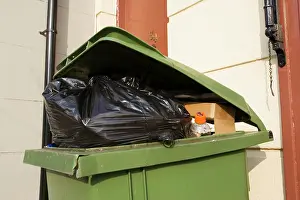 Dustbin: Green wheely bin stuffed full with rubbish