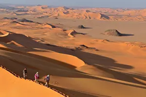 Tourists: Group of people hiking in the sanddunes of Egedi