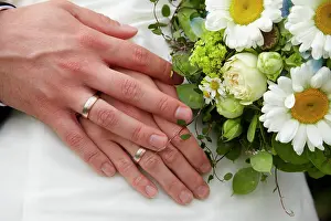 Rings: Hands of the bride and the groom, bridal bouquet