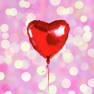 Glitter: Heart shaped balloon on light background, bokeh