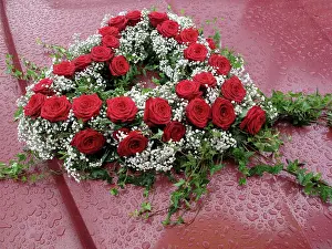 Decoratively: Heart-shaped floral bouquet on a car in the rain