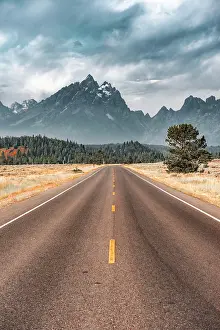 Asphalt: Highway in front of rugged mountains with cloudy