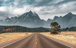 Asphalt: Highway in front of rugged mountains with cloudy