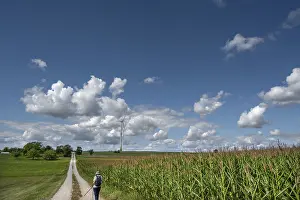 Path: Hiker on a country lane in Franconian landscape