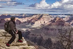 Landmarks: Hiker sitting on the rim of the Grand Canyon