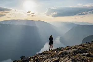 Mountaineer: Hiker taking pictures of fjord landscape, top of