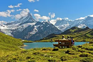Bench: Hikers pausing on a wooden bench at lake Bachalpsee