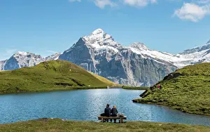 Seating: Hikers resting on a bench, Bachalpsee with summit