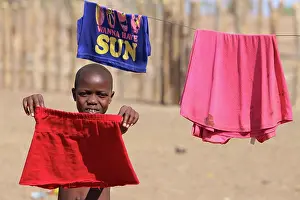 310122: Himba girl helps her mom do the laundry