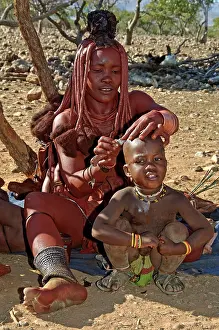 Shaving: Himba lady - shaving boys head with sheath knife