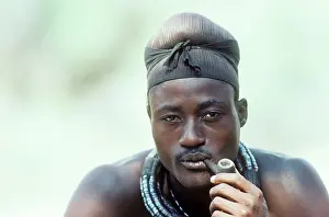 Married: Himba man smoking a pipe - the head scarf indicates