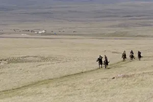 Peoples: Horsemen trotting in pastures near lake Son Kul Kyrgyzstan