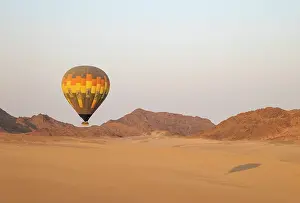 Remote: The hot-air balloon above an arid plain and isolated mountain ridges at the edge of the Namib Desert