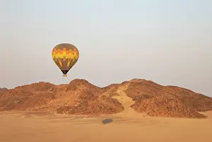 Remote: The hot-air balloon above an arid plain and isolated mountain ridges at the edge of the Namib Desert