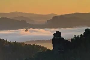 Balloon: Hot air balloon rising in the morning fog at sun