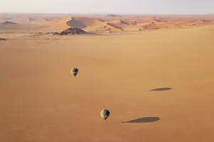 Remote: Two hot-air balloons above an arid plain at the edge of the Namib Desert