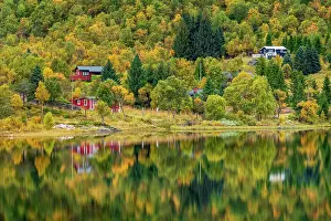 Residential: Houses in autumnal forest reflected in the lake